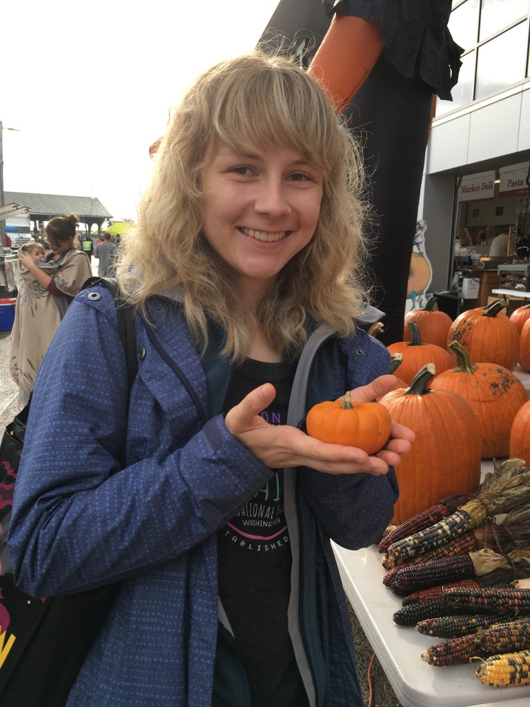 Smiling student holding a small pumpkin