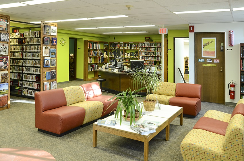 Art & Music Library with shelves of DVDs, plants, cozy couches, magazines, art, and lime green walls