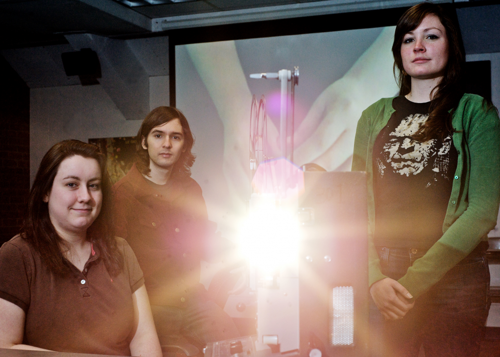 students sitting by an illuminated film projector