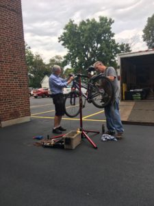 Two men fixing a bicycle