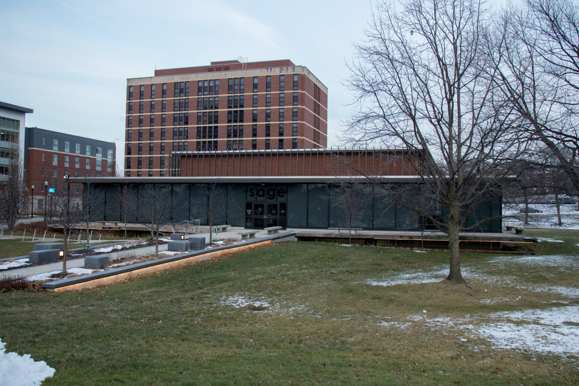 View of the Sage Art Center, a one story square building with tall glass windows.