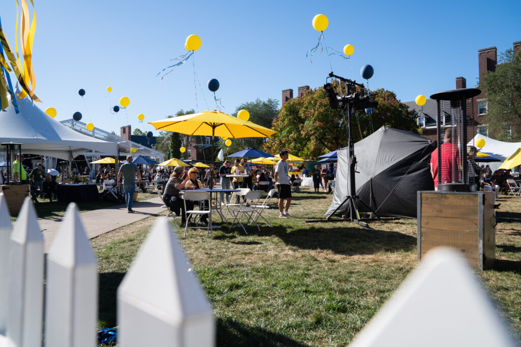 Tents, balloons, and visitors create a festival scene in Meliora Village during Meliora Weekend.