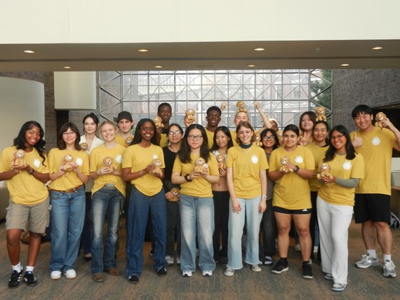 A group of D'Lions pose for a photo holding lion stuffed animals. 