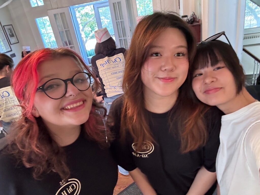 Three friends pose for a selfie in Chi Omega shirts.