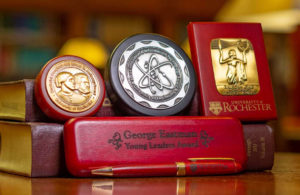 The four High School Awards and a pen placed atop or near a couple of books for display.