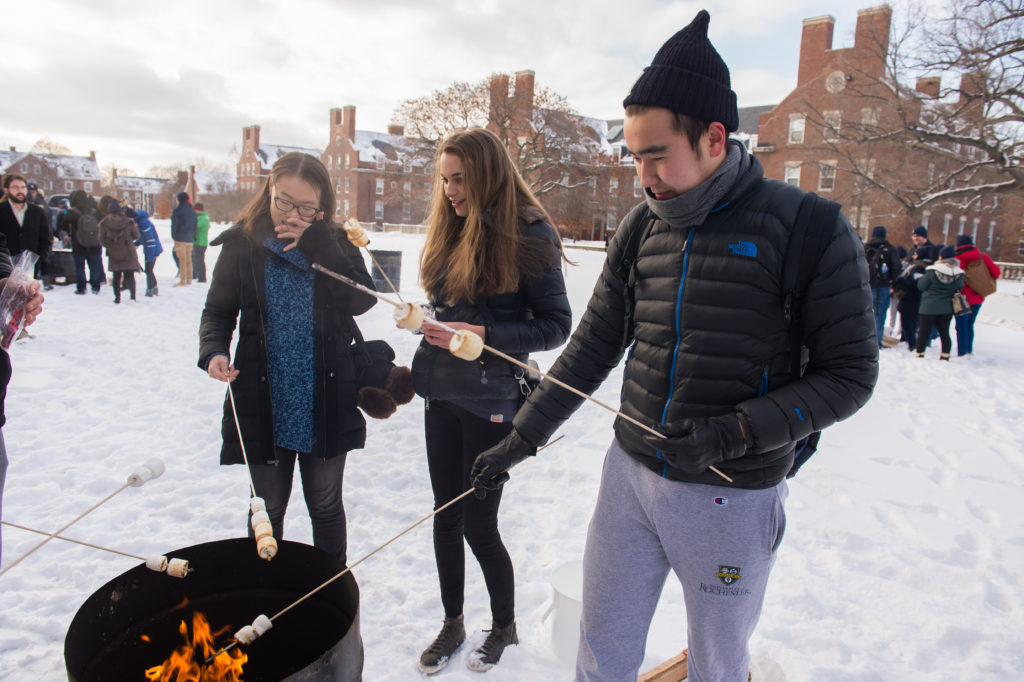 Students roast marshmallows as a part of Winterfest activities.