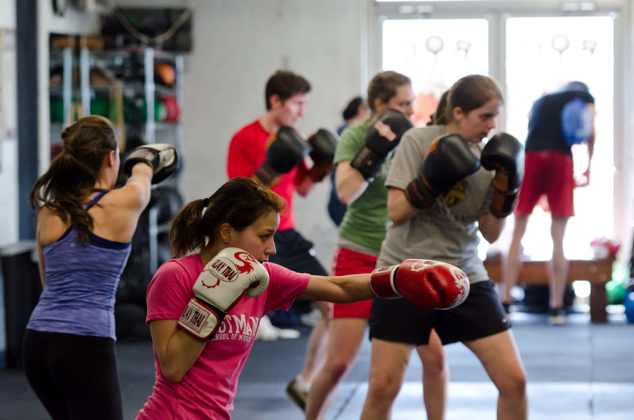 Female and male students at the University of Rochester participating in a boxing fitness class.