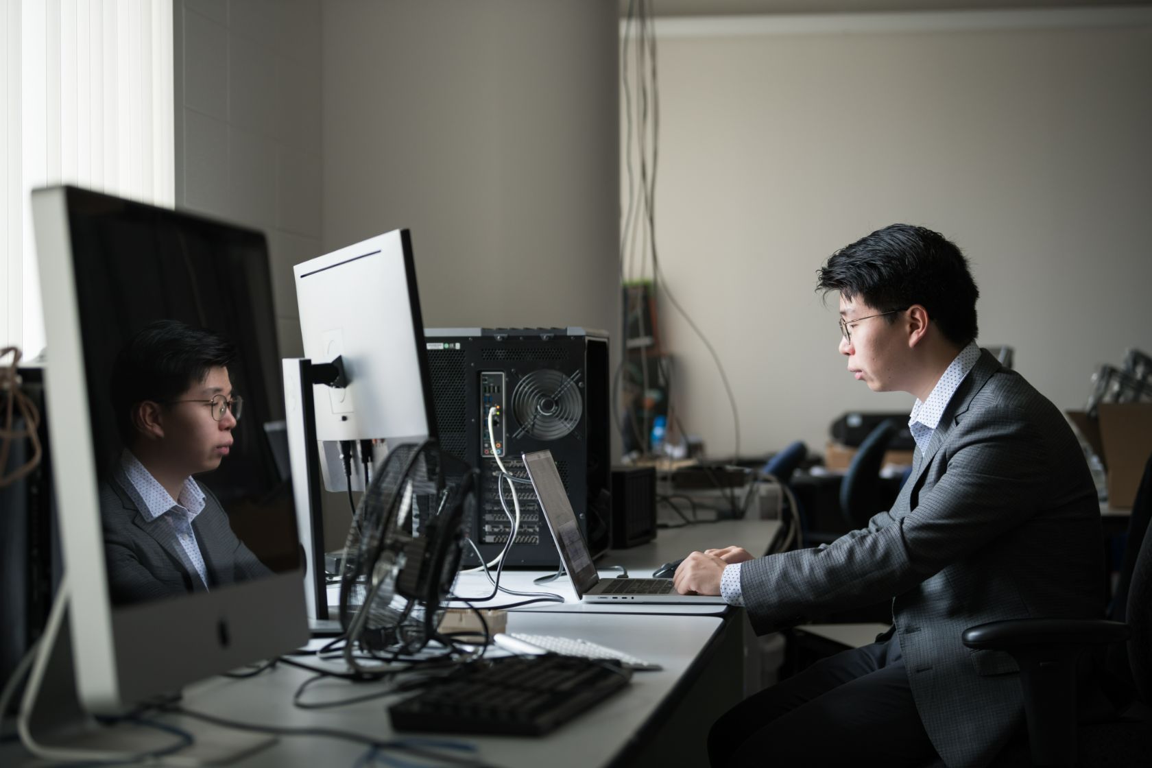 A student sits among many computers reviewing lab results