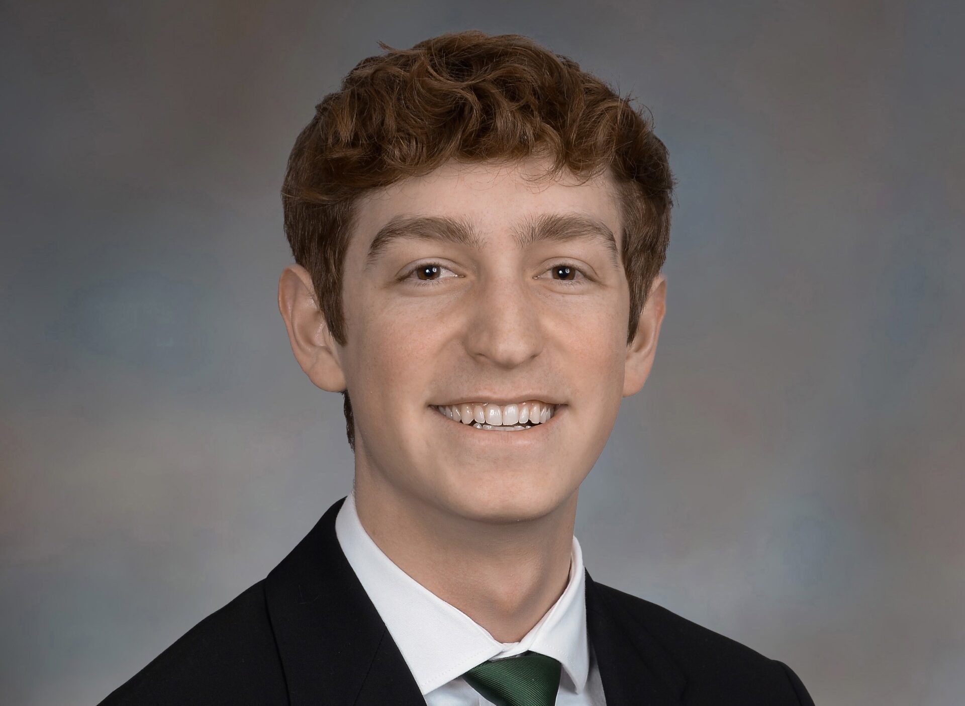 A URochester student in front of a gray background.